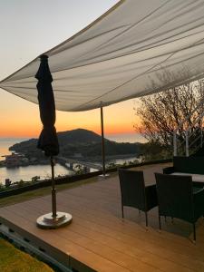 a table and chairs under a white umbrella on a deck at Kamiamakusa - House - Vacation STAY 54914v in Kami Amakusa