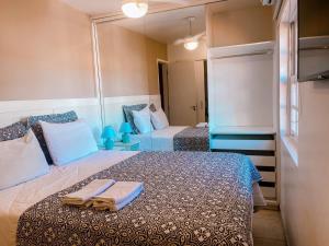 a bedroom with two beds with towels on the bed at Casa Vila da Praia Buzios - Centro in Búzios