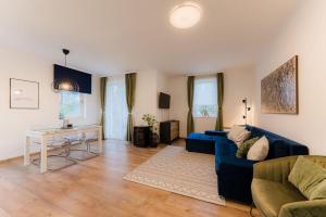 un soggiorno con divano blu e tavolo di Csendes, modern, otthonos társasházi lakás a Zalacsány