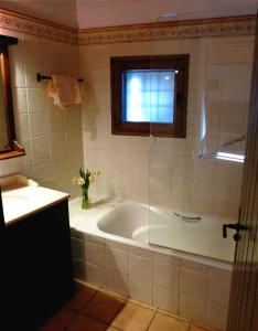 La salle de bains est pourvue d'une baignoire et d'une fenêtre. dans l'établissement Antic Cal Pubill, à Tornafort