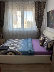 a bed sitting in a room with a window at Adriana home in Turda