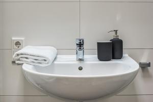 a white sink in a bathroom with towels on it at NorthApartments Dresden am Park in Dresden