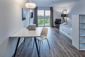 a white apartment with a desk and a bed at NorthApartments Dresden am Park in Dresden
