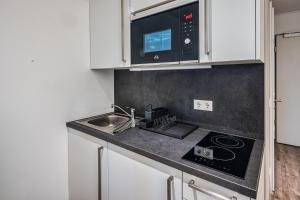 a kitchen with a sink and a microwave at NorthApartments Dresden am Park in Dresden