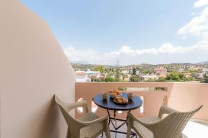 a table and chairs on a balcony with a view at Filia Apartments in Pitsidia
