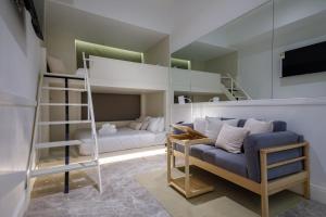 a bedroom with bunk beds with a couch and a ladder at Charterhouse Causeway Bay in Hong Kong