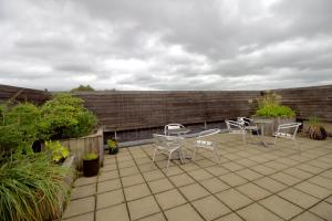 a patio with chairs and tables and a brick wall at Old Exchange Court in Belfast