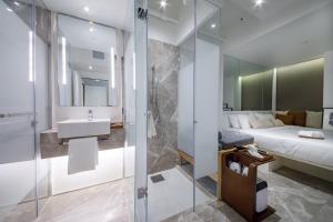 bagno con doccia, letto e lavandino di Charterhouse Causeway Bay a Hong Kong Altre 24 foto