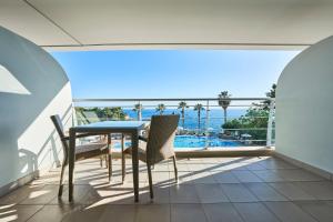 einen Balkon mit einem Tisch und Stühlen sowie Meerblick in der Unterkunft Melia Madeira Mare in Funchal