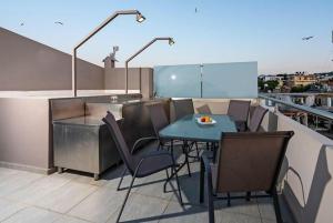 a patio with a table and chairs on a balcony at Villa Miami in Agia Marina Nea Kydonias