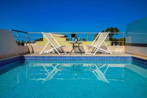 - Piscina con mesa y 2 sillas en Villa Miami, en Nea Kydonia