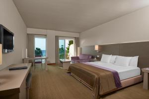 a hotel room with a large bed and a desk at Melia Madeira Mare in Funchal