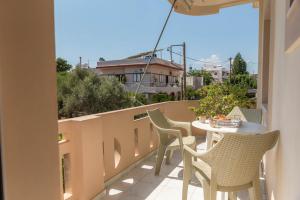 a patio with chairs and a table on a balcony at Filia Apartments in Pitsidia