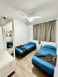 ein Schlafzimmer mit zwei Betten und einem Spiegel in der Unterkunft Rambla Apartment by the Sea in Alicante