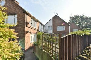 a brick house with a wooden fence in front of it at Spacious 3 Bedroom, 2 bathroom House in Pontefract
