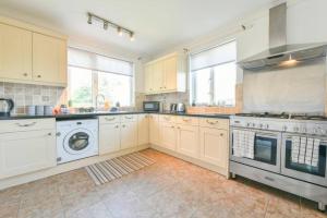 a kitchen with white cabinets and a washer and dryer at Spacious 3 Bedroom, 2 bathroom House in Pontefract