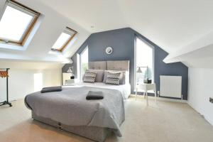 1 dormitorio con 1 cama grande, paredes y ventanas azules en Spacious 4 Bedroom, 2 bathroom House, en Pontefract