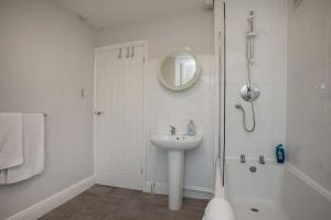 a white bathroom with a sink and a shower at Cozy 3 bedroom house @ Hömli in Loughborough