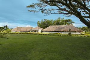 eine Reihe von Gebäuden mit einem großen Grasfeld in der Unterkunft Hotel Cinaruco Caney in Villavicencio