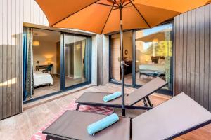 un patio avec un parasol, une table et des chaises dans l'établissement Villa Renajolo 16 pers piscine chauffée 2 min plage en voiture, à Sainte-Lucie de Porto-Vecchio 44 autres photos