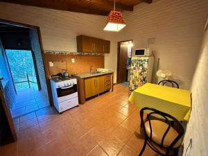eine Küche mit einem Tisch und einer gelben Arbeitsplatte in der Unterkunft La Posada De Gogg Apartamentos in Bella Vista