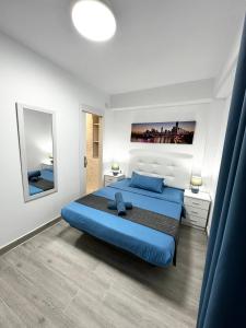 a bedroom with a large blue bed in a room at Rambla Apartment by the Sea in Alicante
