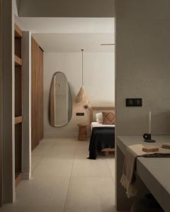 ein Schlafzimmer mit einem Bett und einem Spiegel in einem Zimmer in der Unterkunft The Syntopia Hotel - Adults Only in Adelianos Kampos