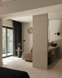 - une chambre avec un lit, un lavabo et un miroir dans l'établissement The Syntopia Hotel - Adults Only, à Adelianos Kampos