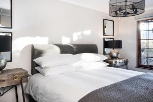 a bedroom with a white bed with white pillows at Avemore Orchard Apartment - with full Backup power in Stellenbosch +30 photos
