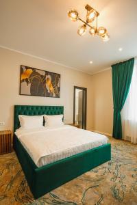 a bedroom with a large bed with a green headboard at Motel Andra in Tecuci