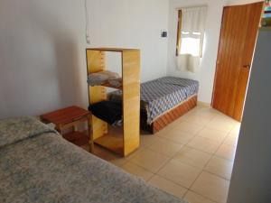 a bedroom with a mirror and a bed and a table at Aldea Serrana in Tandil