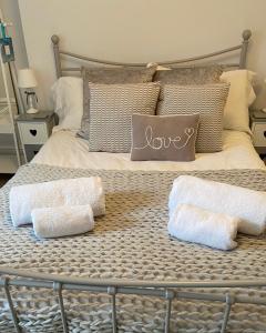 a bed with two towels and a love pillow on it at Seaspray Boutique Whitby Apartment in Whitby