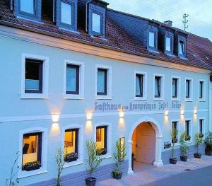 Zum Kronprinzen Hotel Garni في Weyher: مبنى أبيض أمامه ممر