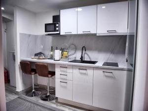 a kitchen with white cabinets and a sink at VitaminSea - Lovran in Lovran