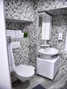 a bathroom with a sink and a toilet and a mirror at VitaminSea - Lovran in Lovran