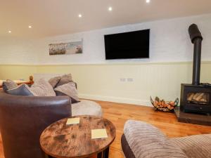 a living room with a couch and a fire place at Carew Lodge & Loft in Torpoint
