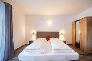 a bedroom with a large white bed with white pillows at Ferienwohnung Berger in Avelengo