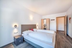 1 dormitorio con 2 camas blancas en una habitación en Ferienwohnung Bergerr, en Avelengo