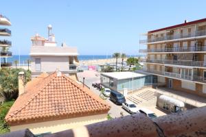 een balkon met uitzicht op een gebouw en een strand bij 102 I Posada del Mar I Encantador hostel en la playa de Gandia in Los Mártires