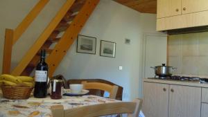 a kitchen with a table with a bottle of wine at Il Quadrifoglio 4 in Procchio