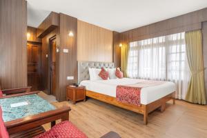 a hotel room with a bed and a couch at Summit Tashi Ghang Heritage Resort in Pelling