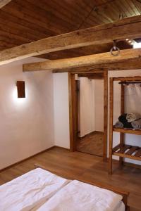 um quarto com uma cama e um tecto de madeira em Salaš u Bregu in Cheile Carasului em Caraşova