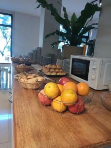 una mesa con cestas de fruta y un microondas en Alsina Suites en Mar del Plata