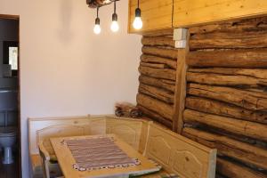 comedor con mesa y pared de madera en Salaš u Bregu in Cheile Carasului, en Caraşova