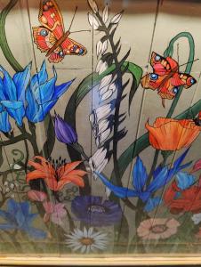 a painting of butterflies and flowers in a vase at The Lampet Arms in Banbury