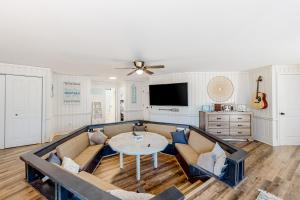 ein Wohnzimmer mit einem Sofa und einem Tisch in der Unterkunft Beach House in Kill Devil Hills
