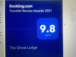 Granity的住宿－The Ghost Lodge，带有闹钟的客人旅舍标志的屏幕