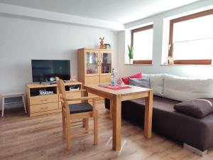 sala de estar con mesa y sofá en Ferienwohnung Trifts | Einzelbetten | Parkplatz, en Wangen im Allgäu