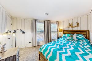 1 dormitorio con cama, escritorio y ventana en Beach House, en Kill Devil Hills