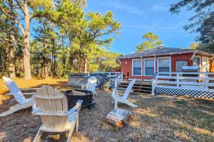 um grupo de cadeiras sentadas em frente a uma casa em Beach House em Kill Devil Hills